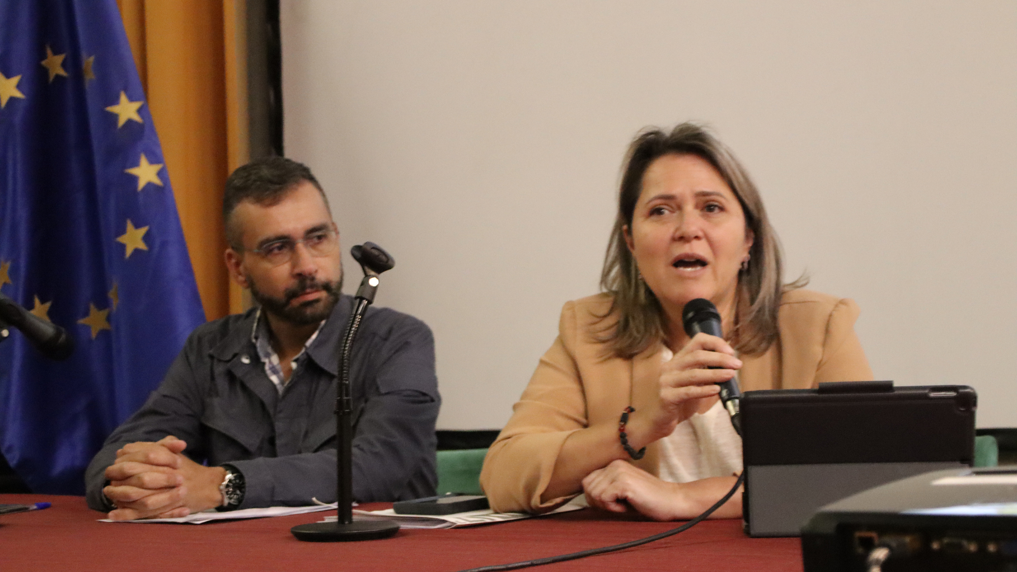 Alicia Vanoostende (micrófono) explica a los afectados por el volcán de La Palma el borrador de reparcelación./ CEDIDA