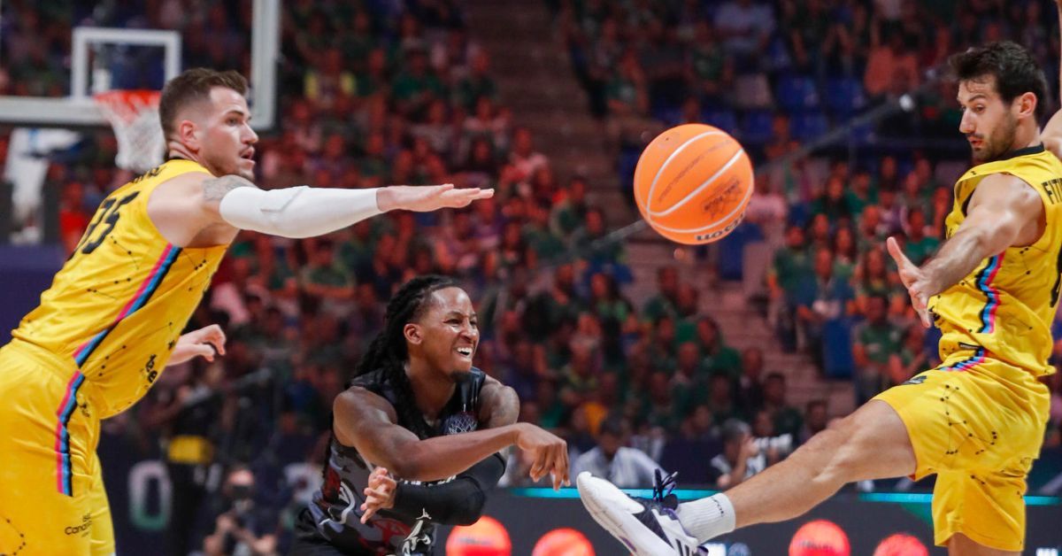 Fran Guerra y Bruno Fitipaldo tratan de interceptar un pase de Speedy Smith en la derrota por 68-69 del CB Canarias ante Hapoel Jerusalén./ EFE.