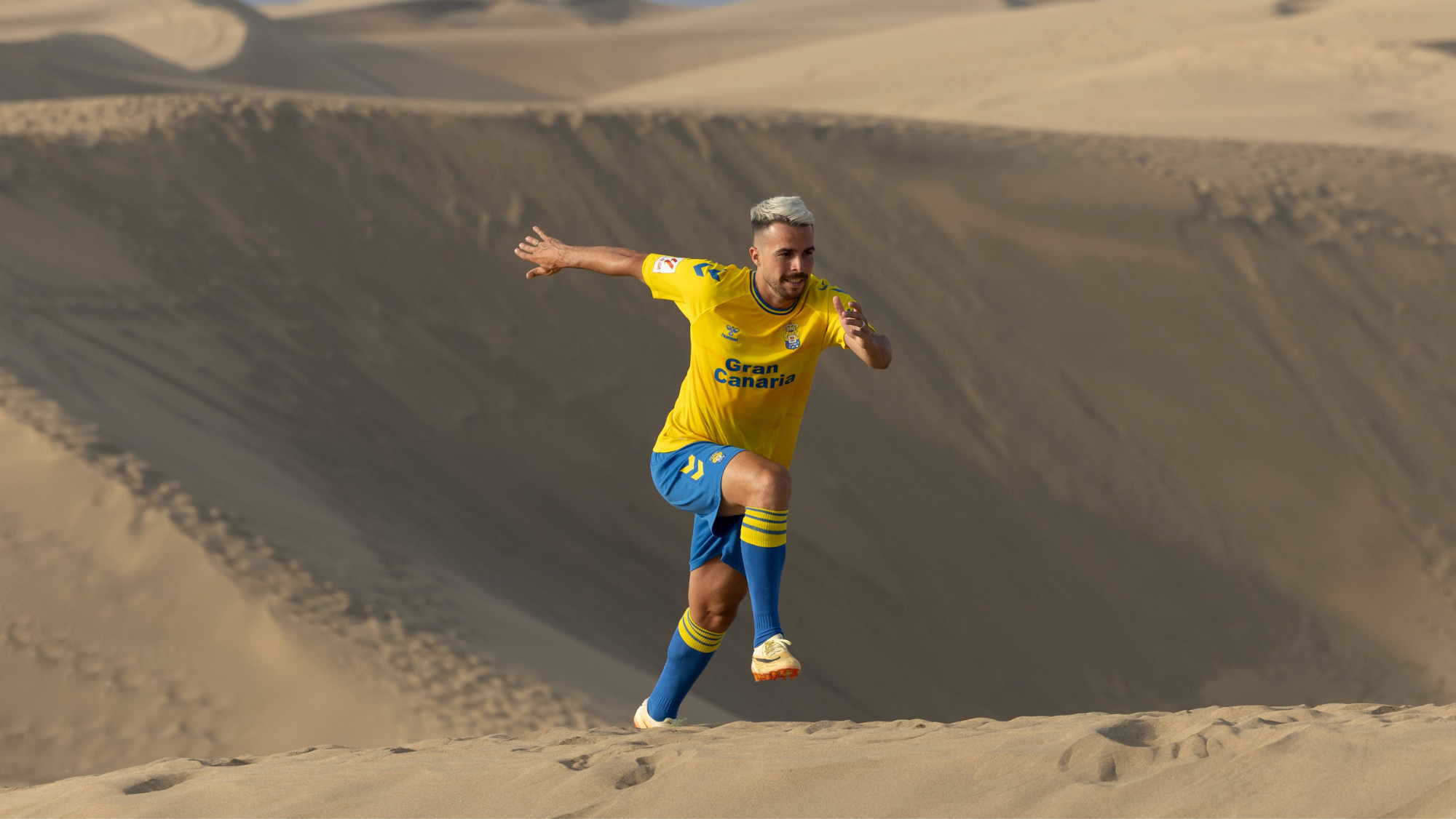 Kirian, jugador de la UD Las Palmas, presentando la nueva equipación en las dunas de Maspalomas./ UD LAS PALMAS