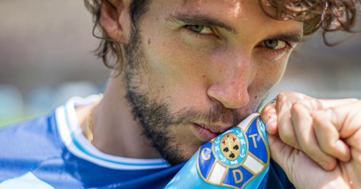 Corredera besa el escudo del Tenerife en la presentación de la segunda equipación para la nueva temporada./ CD TENERIFE.