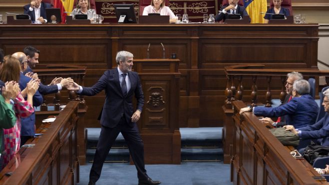 Fernando Clavijo, felicitado por su grupo parlamentario tras ser investido presidente del Gobierno de Canarias, se dirige a saludar a Ángel Victor Torres, presidente saliente. / MIGUEL BARRETO-EFE