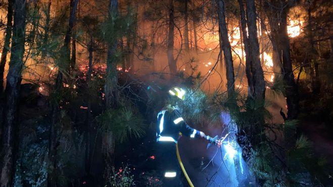 Un efectivo terrestre lucha contra el incendio de La Palma en la noche / @EMERGENCIAS_GC