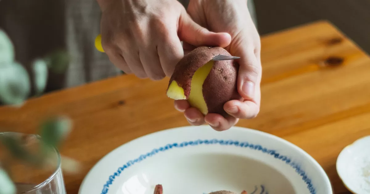 Una persona pelando una papa. / DILIARA GARIFULLINA 