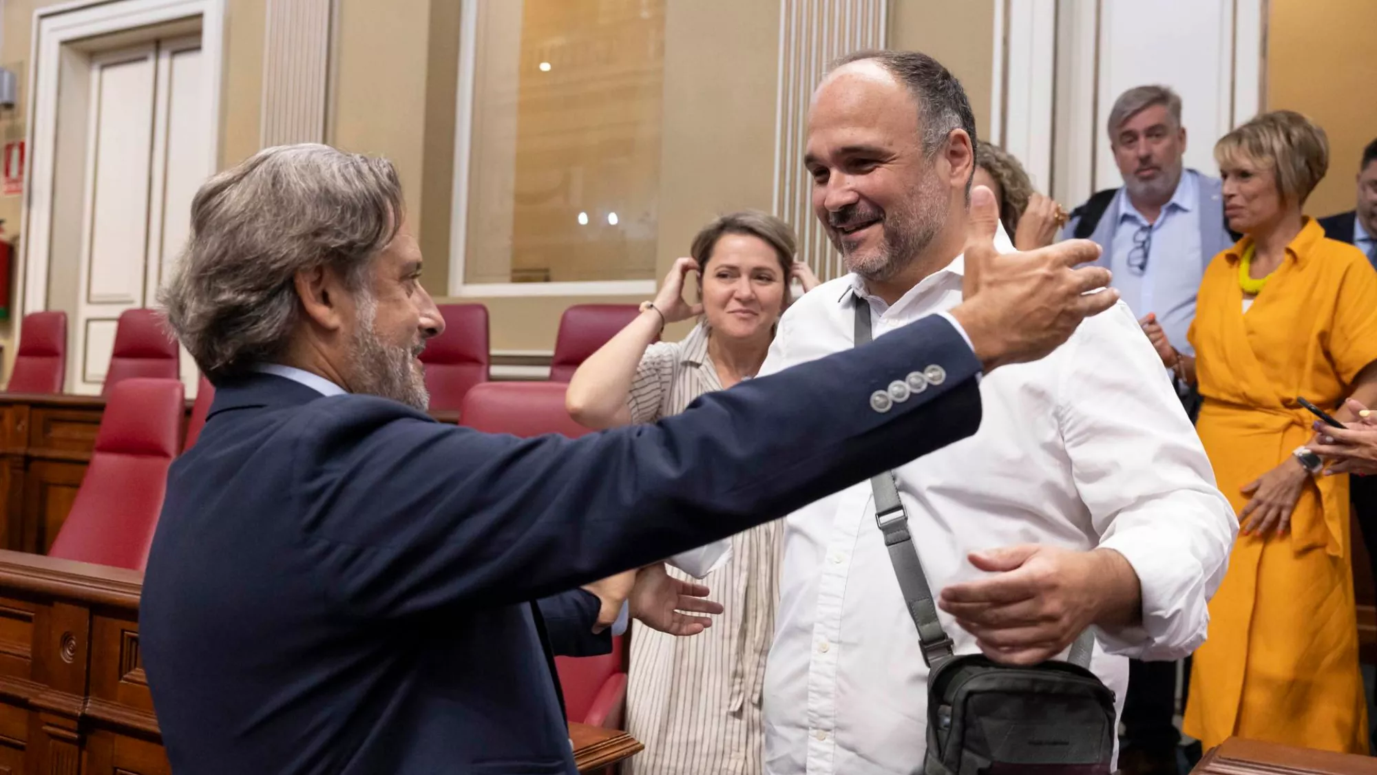 José Antonio Valbuena, nuevo senador autonómico por Canarias (de blanco), recibe el abrazo de su compañero del PSOE, Gustavo Matos./ EFE