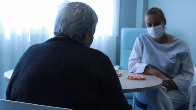 Una residente de CleceVitam Vía Ronda participa en una actividad junto a una empleada del centro. / AH