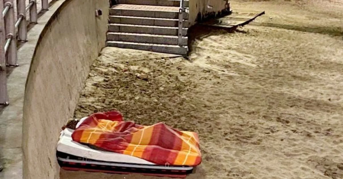 Insólita imagen de dos hombres durmiendo con canapé, somier, colchón y manta en Las Canteras. MI PLAYA DE LAS CANTERAS.COM