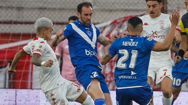 Matías Cóccaro, a la derecha de la imagen, en una disputa con Godín durante un partido entre Huracán y Vélez Sarsfield. / JUAN IGNACIO RONCORONI EFE
