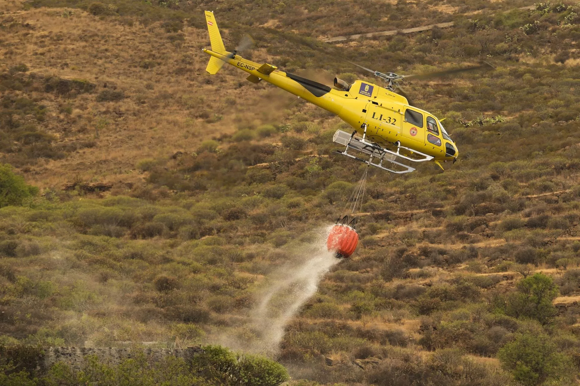 Un helicóptero Bandit trabajando en las labores de extinción del incendio de Tenerife, recargando agua en un tanque del municipio de Arafo. EFE/Alberto Valdés