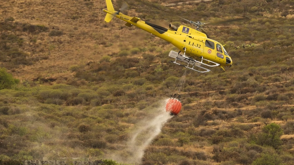 Un helicóptero Bandit trabajando en las labores de extinción del incendio de Tenerife, recargando agua en un tanque del municipio de Arafo. EFE/Alberto Valdés