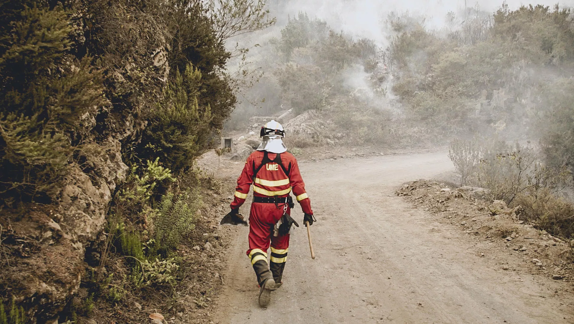 Un bombero de la UME camina por una pista forestal en uno de los frentes del incendio de Tenerife./ UME/EFE