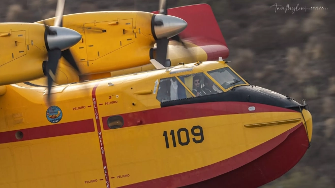 El teniente Pablo Llobell con la bandera de Canarias en uno de los hidroaviones del incendio forestal de Tenerife que trabajaban nueve horas diarias / CEDIDA