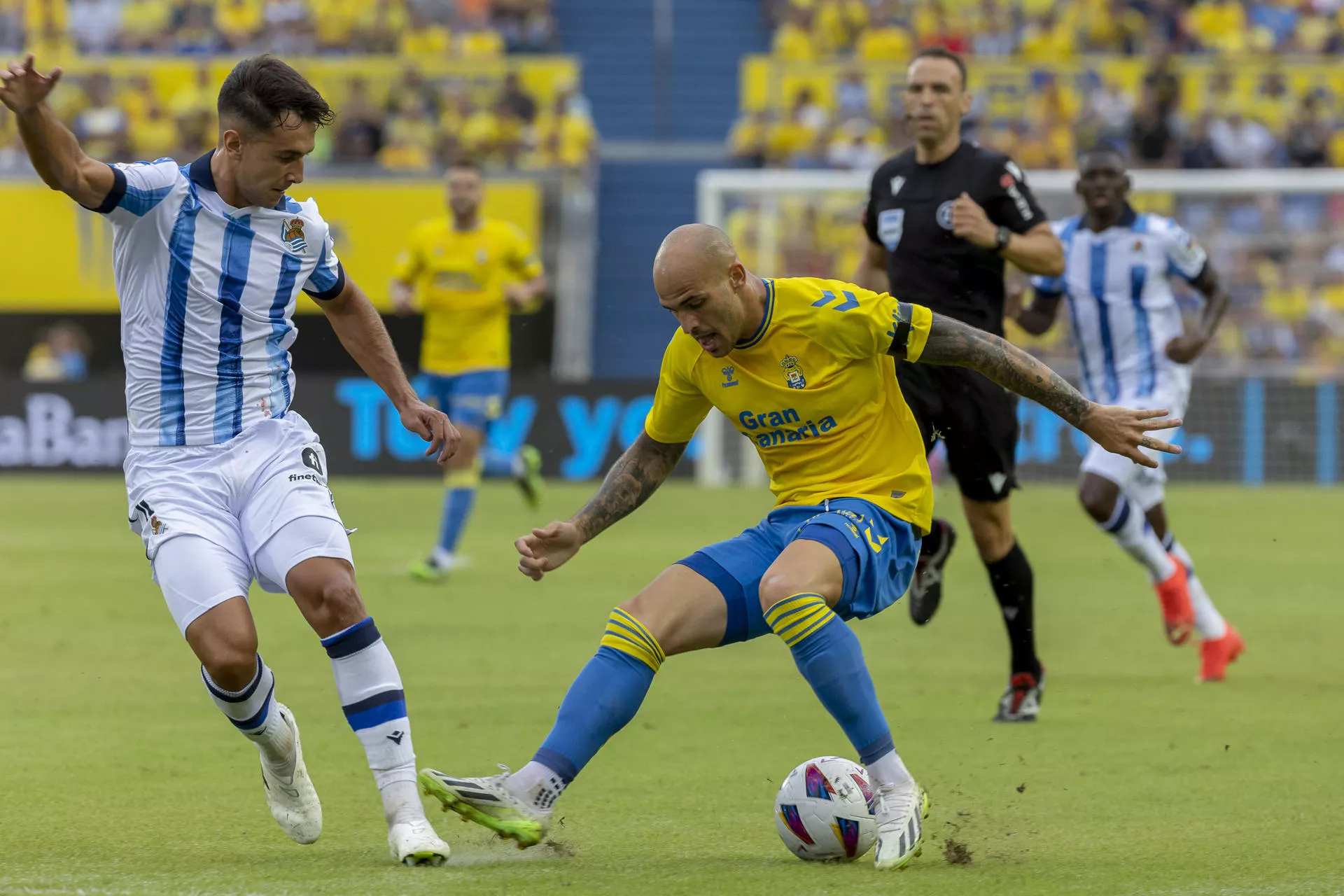 El delantero de la UD Las Palmas Sandro Ramírez (d) lucha con Martín Zubimendi, de la Real Sociedad, durante el partido de la tercera jornada de Liga en Primera División que UD Las Palmas y Real Sociedad./ EFE - QUIQUE CURBELO