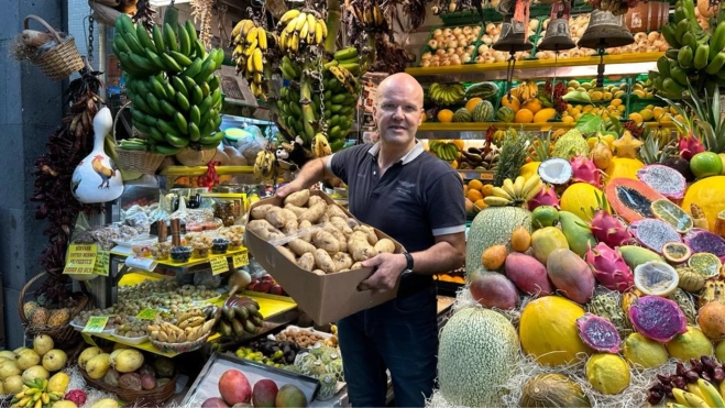 José Quintana carga una caja de papas en su puesto / MARCOS MORENO - ATLÁNTICO HOY