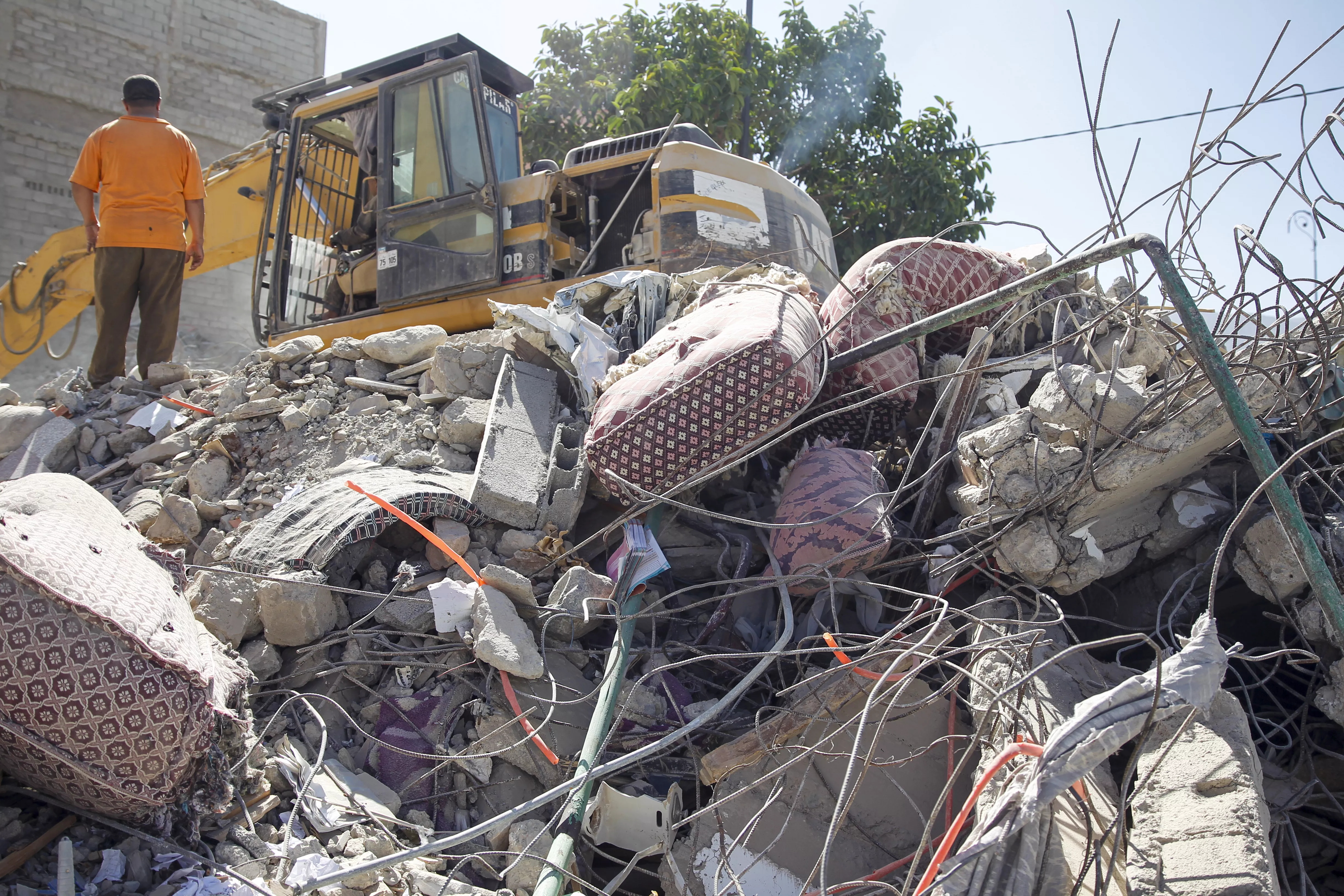 Una máquina excavadora ayuda en las tareas de búsqueda de supervivientes entre los escombros de edificios derruidos en la población de Amizmiz, situada a unos 30 kilómetros del epicentro del terremoto, en las faldas del Atlas. / MARÍA TRASPADERNE-EFE