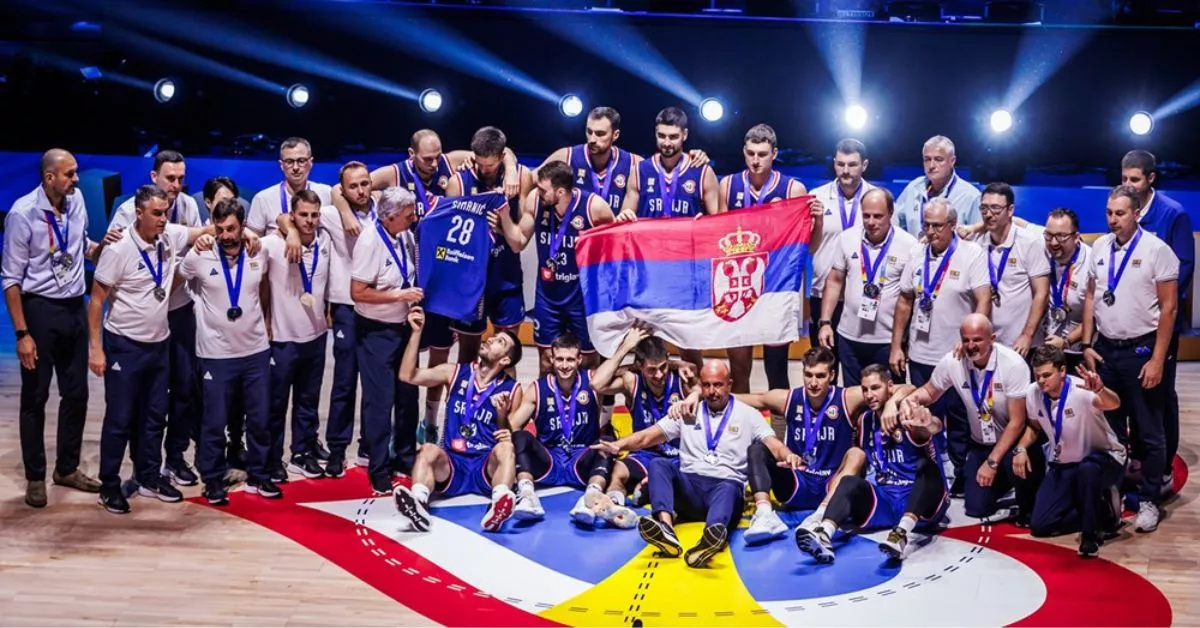 El jugador del CB Canarias, Dusan Ristic (de pie sosteniendo la bandera) posa junto al combinado serbio con la medalla de plata al cuello./ FIBA.
