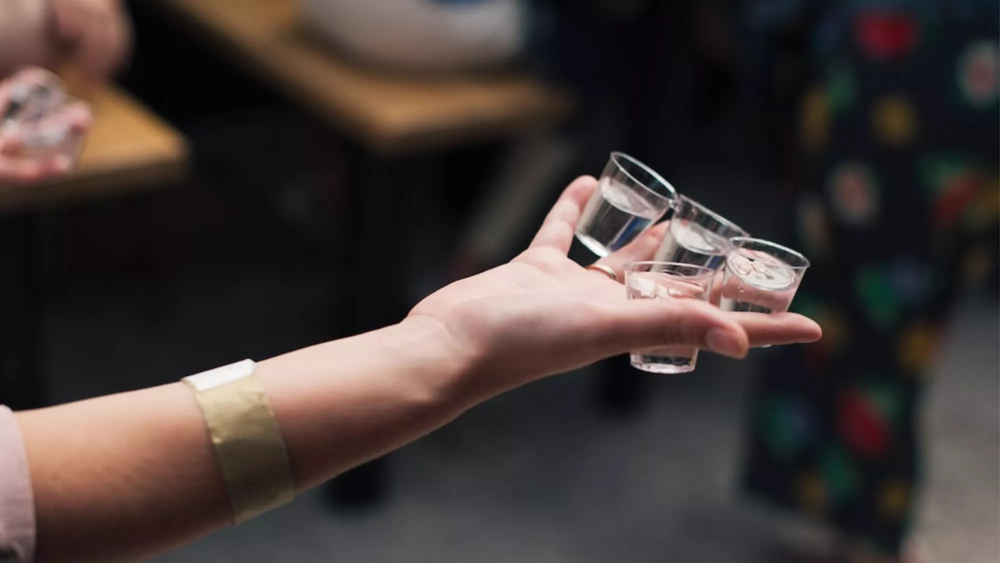 Imagen de una persona sujetando varios chupitos de vodka / UNSPLASH