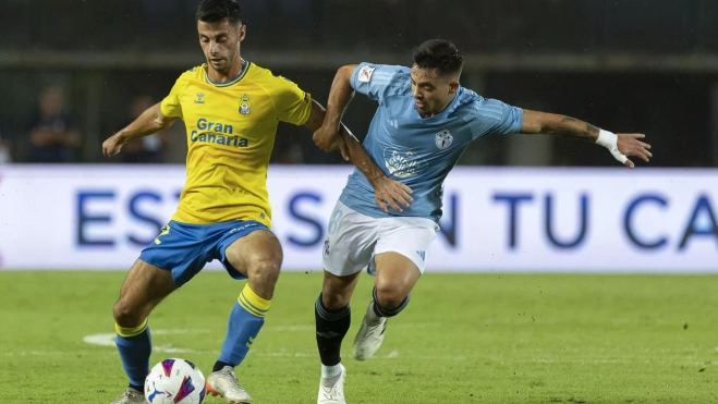 El centrocampista francés de Las Palmas Enzo Loiodice (i) pelea un balón con el centrocampista del Celta Fran Beltrán durante el partido. / EFE - QUIQUE CURBELO
