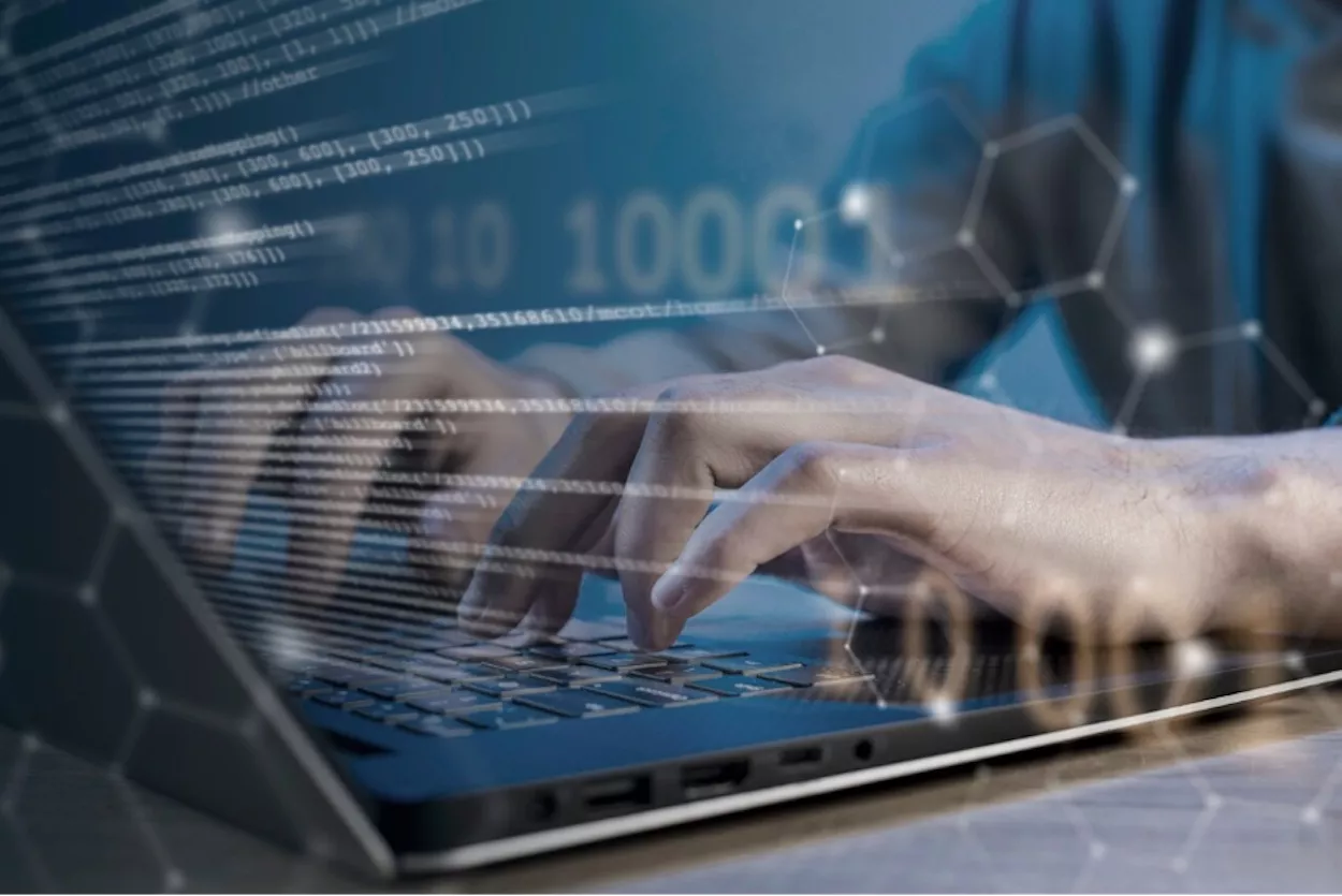 Un hombre teclea en un portátil