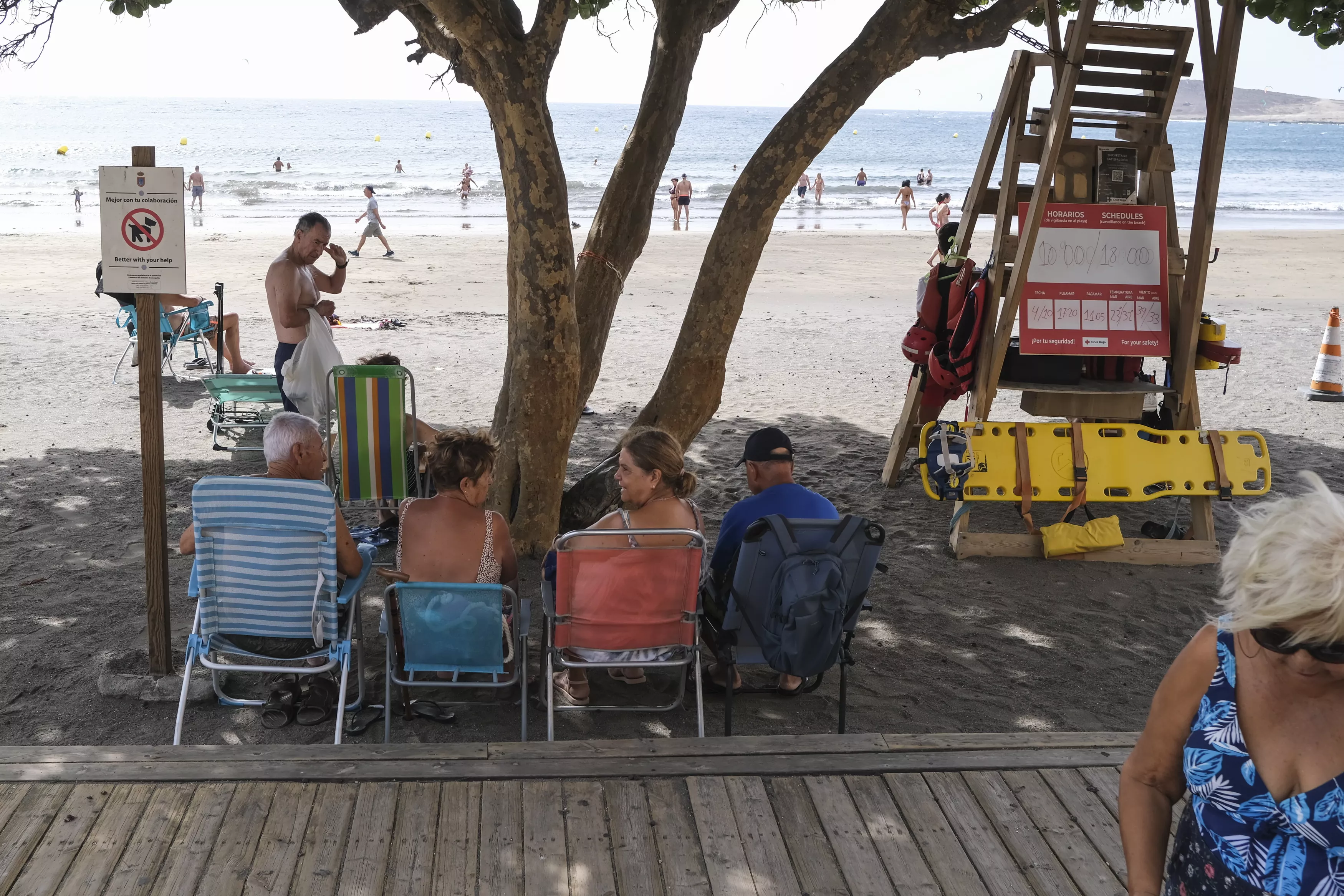 Varias personas se protegen del calor en la playa de El Médano en Tenerife. / EFE
