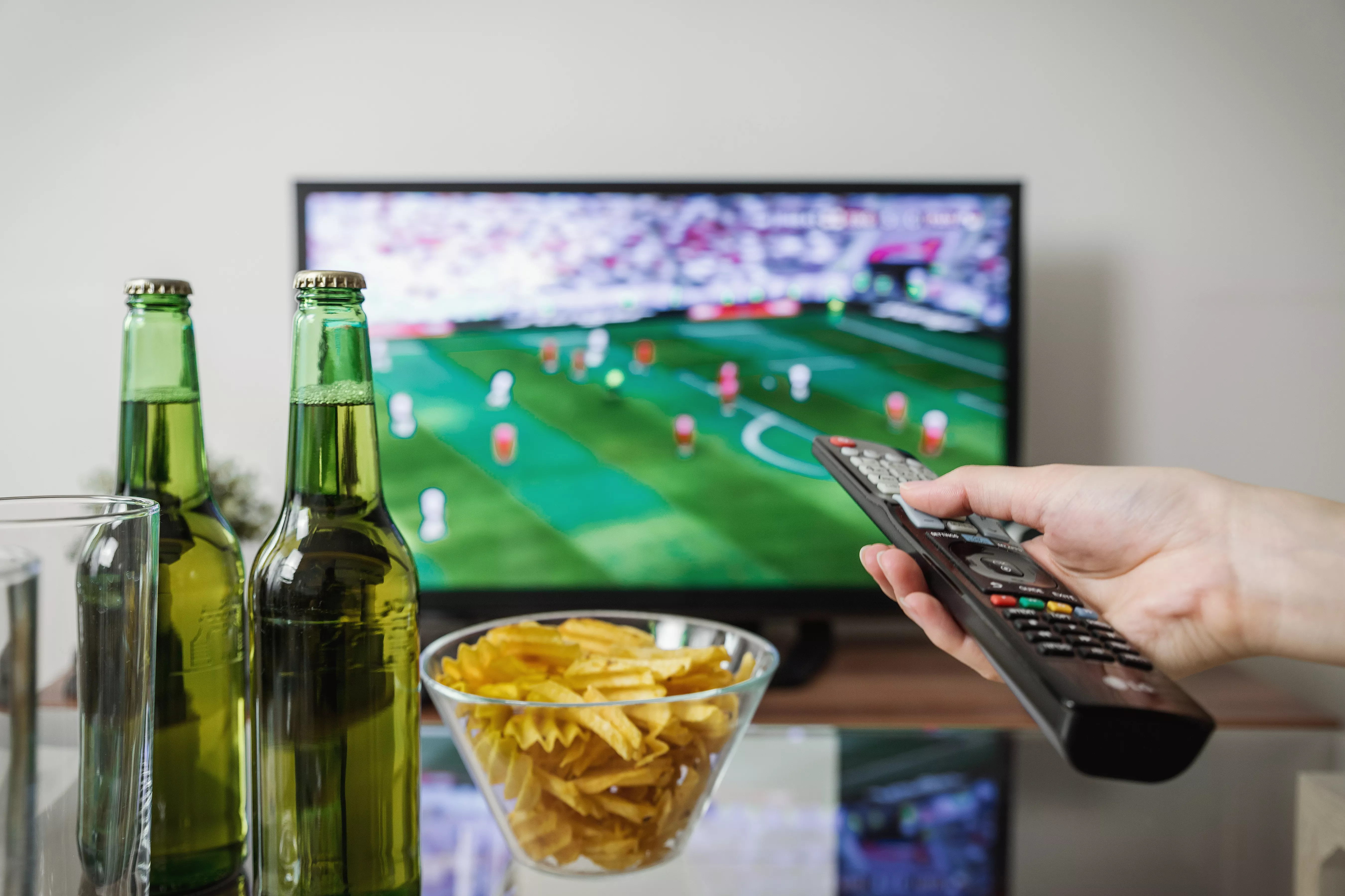 Partido de fútbol en televisión con un aperitivo / PEXELS