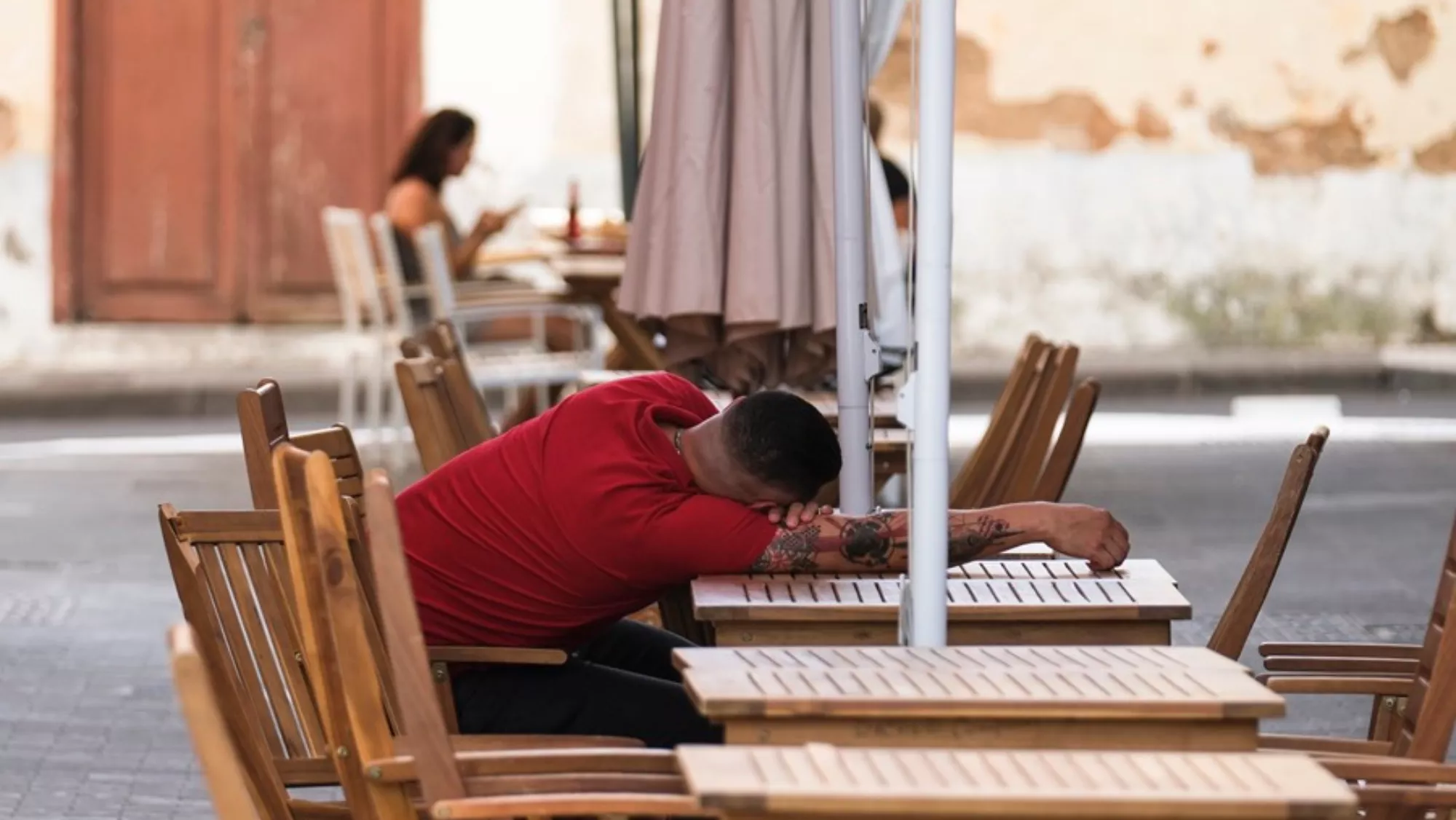 Un hombre descansa sobre una mesa en La Laguna / EFE - ALBERTO VALDÉS