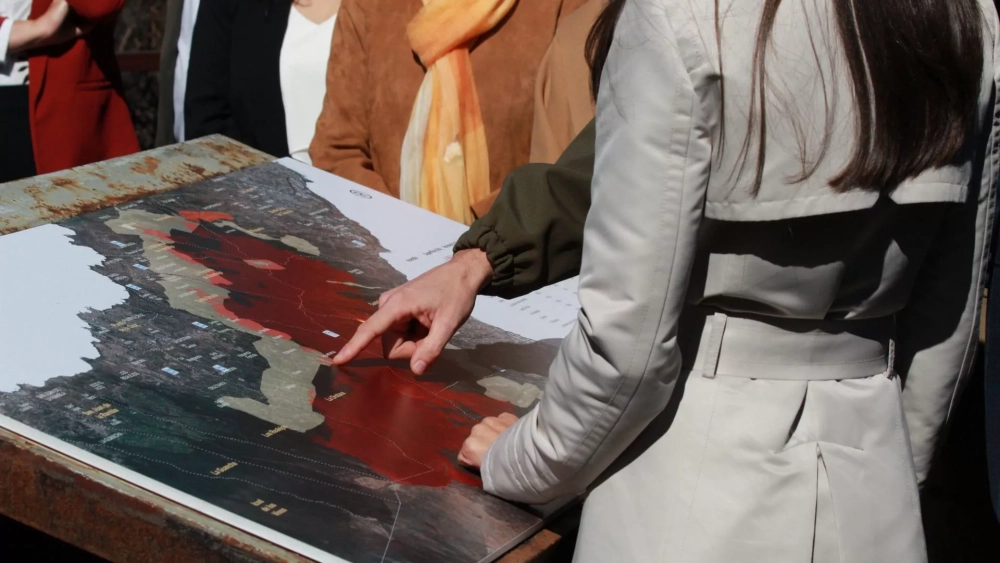 Pedro Martínez enseña a los reyes el incendio sobre un panel instalado en Chipeque./ ÁLVARO OLIVER - AH