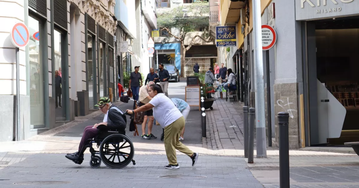 Una mujer empuja a un hombre dependiente en Santa Cruz de Tenerife (Canarias). / ATLÁNTICO HOY