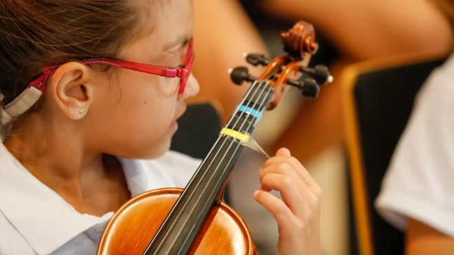 Kendra, una de las niñas que participa en el proyecto tocando el violín / EFE -ELVIRA URQUIJO