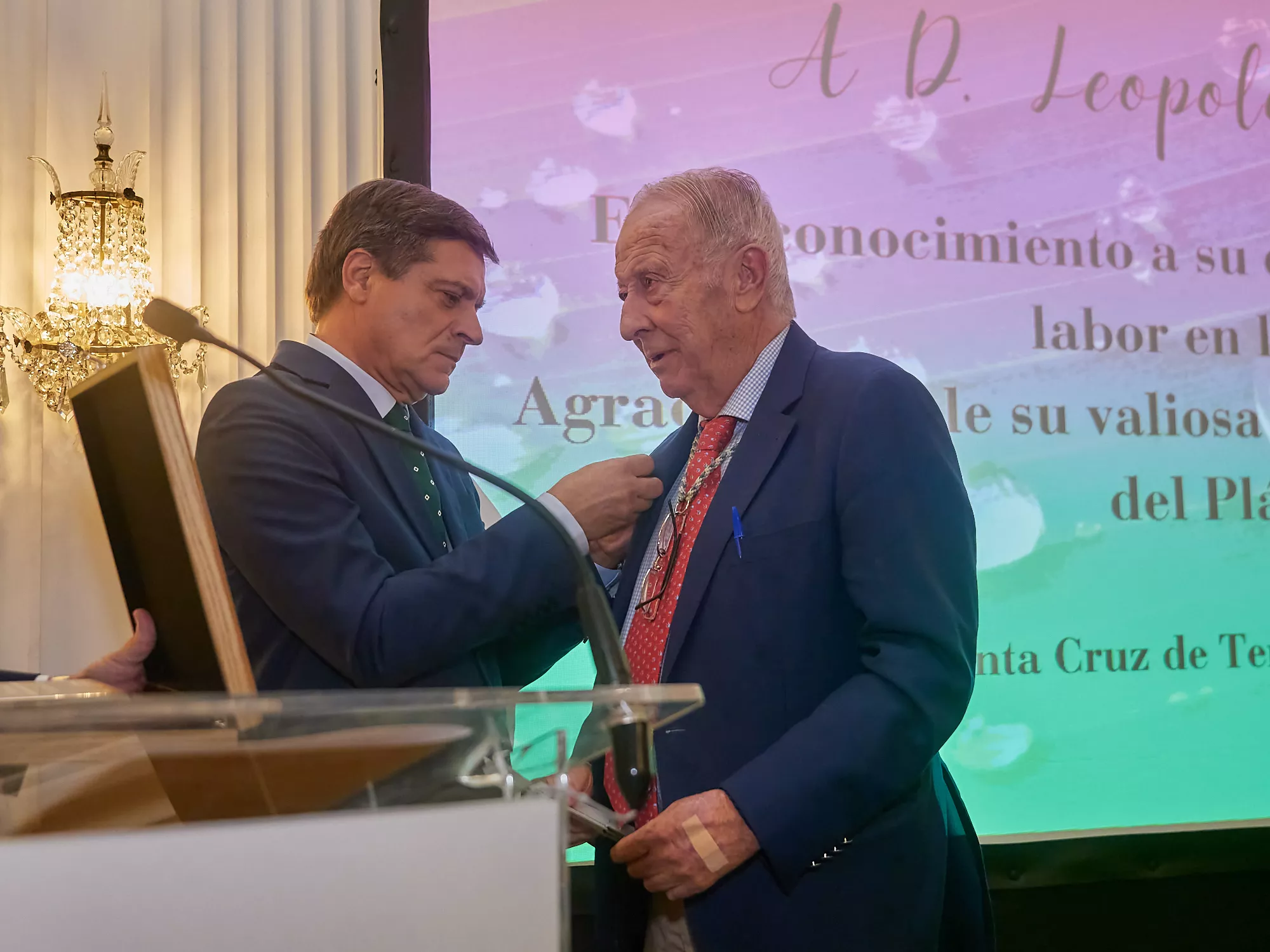 El presidente de Asprocan (Plátano de Canarias)), Domingo Martin, le coloca la insignia homenaje a Leopoldo Cologan / CEDIDA El presidente de Asprocan (Plátano de Canarias)), Domingo Martin, le coloca la insignia homenaje a Leopoldo Cologan / CEDIDA