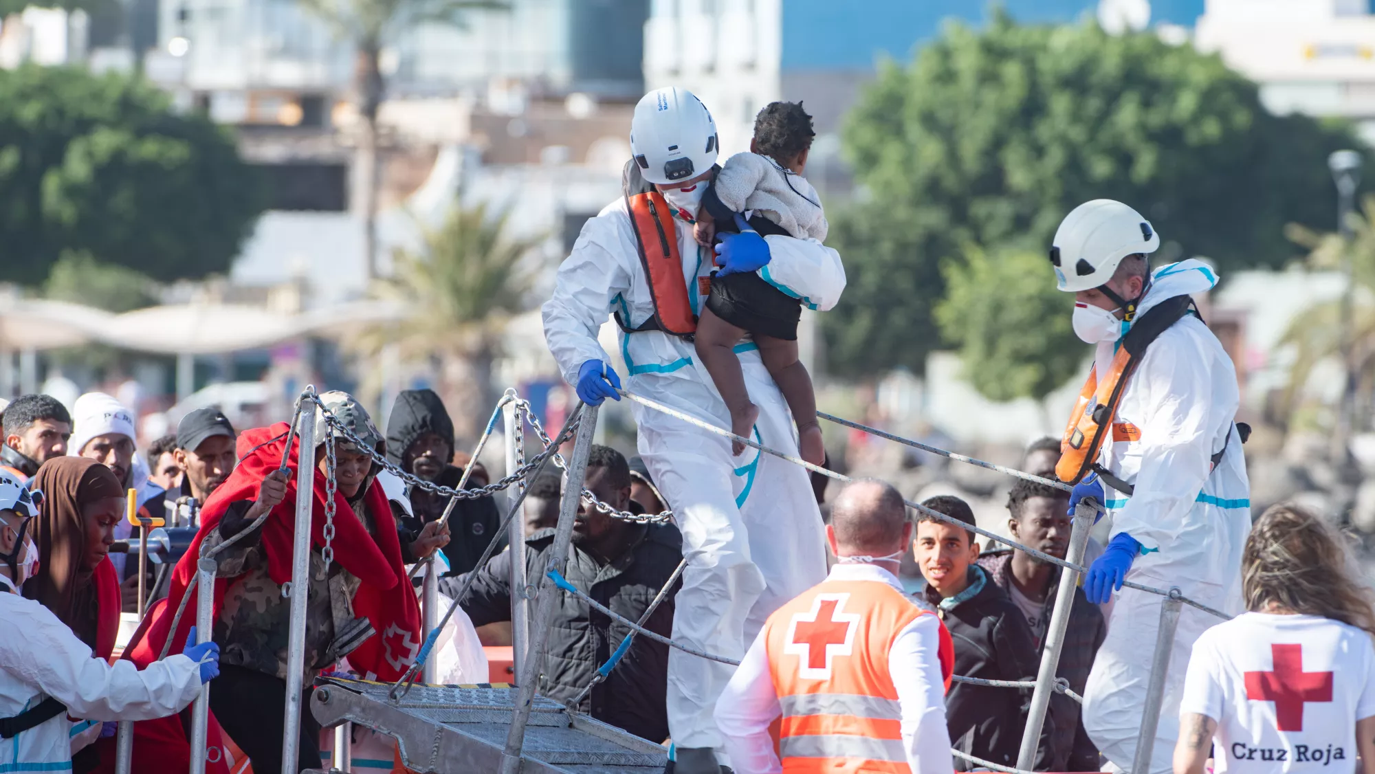 Un trabajador de Cruz Roja ayudando a un menor migrante a desembarcar / EFE Un trabajador de Cruz Roja ayudando a un menor migrante a desembarcar / EFE