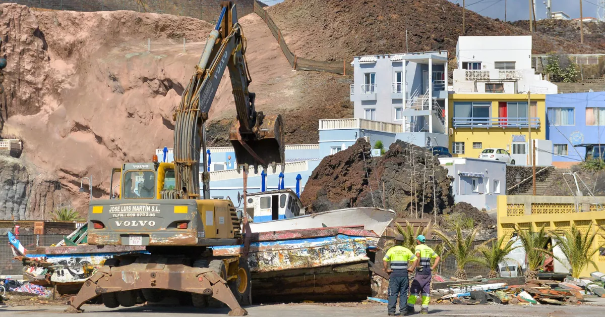 Varios operarios se encargan de sacar del muelle de La Restinga (El Hierro) los cayucos acumulados en las instalaciones portuarias. EFE/ Gelmert Finol