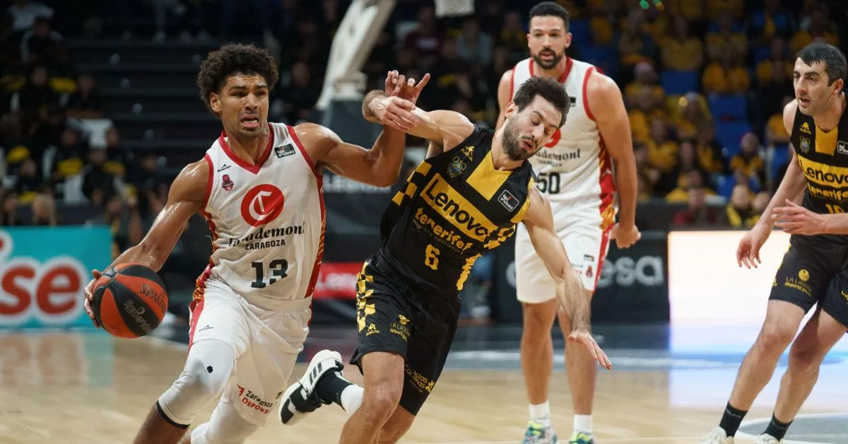 Mark Smith y Fitipaldo pugnan por el balón sobre la pista del Santiago Martín, donde el Canarias cedió por 64-70 ante la remontada de Casademont Zaragoza./ RAMÓN DE LA ROCHA.