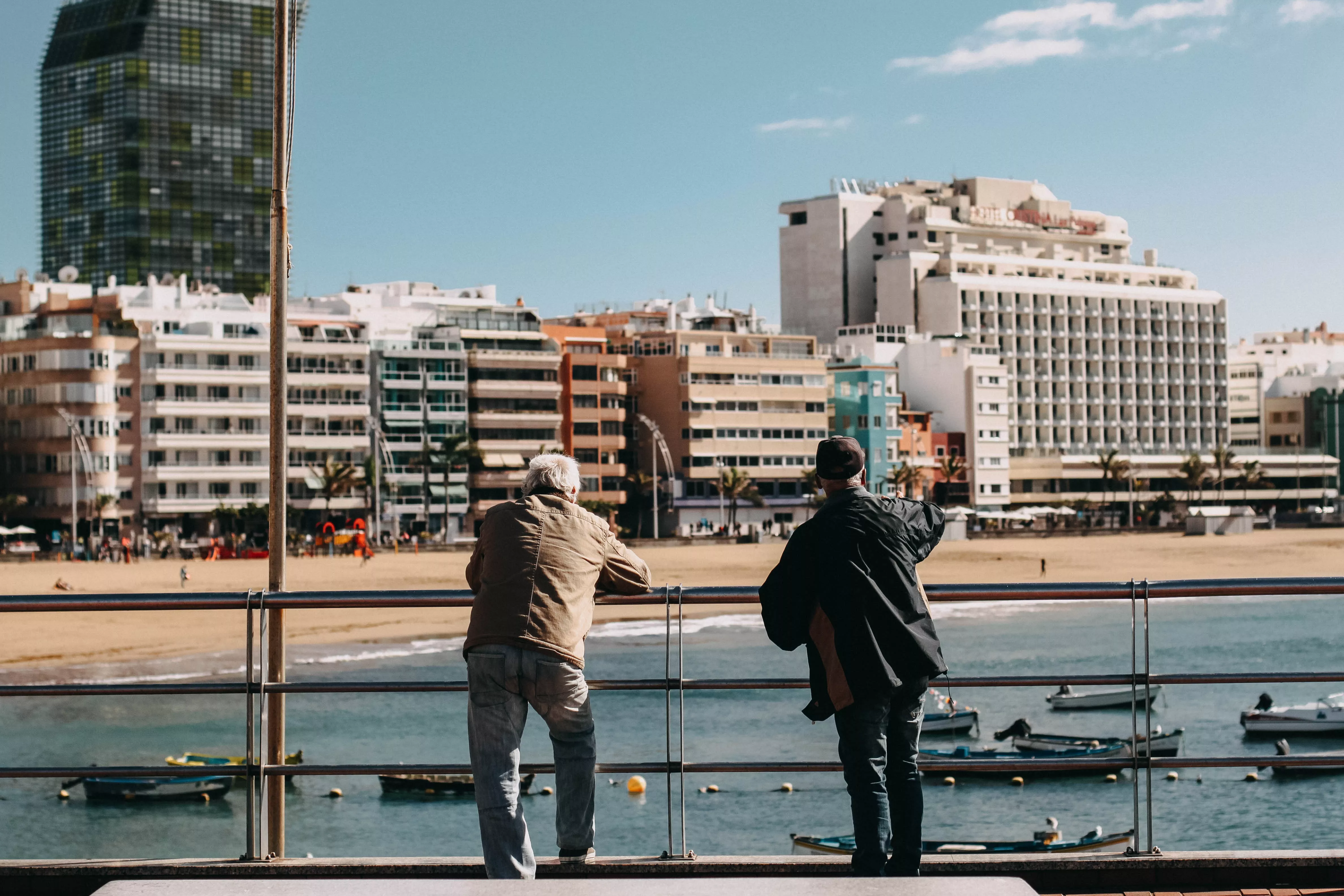 Dos personas en Las Canteras, Las Palmas de Gran Canaria, uno de los municipios que ha caído en número de habitantes en 2023. / UNSPLASH