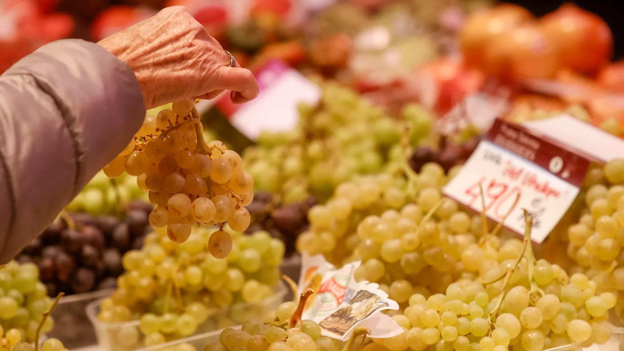 Persona comprando uvas en el mercado / EFE