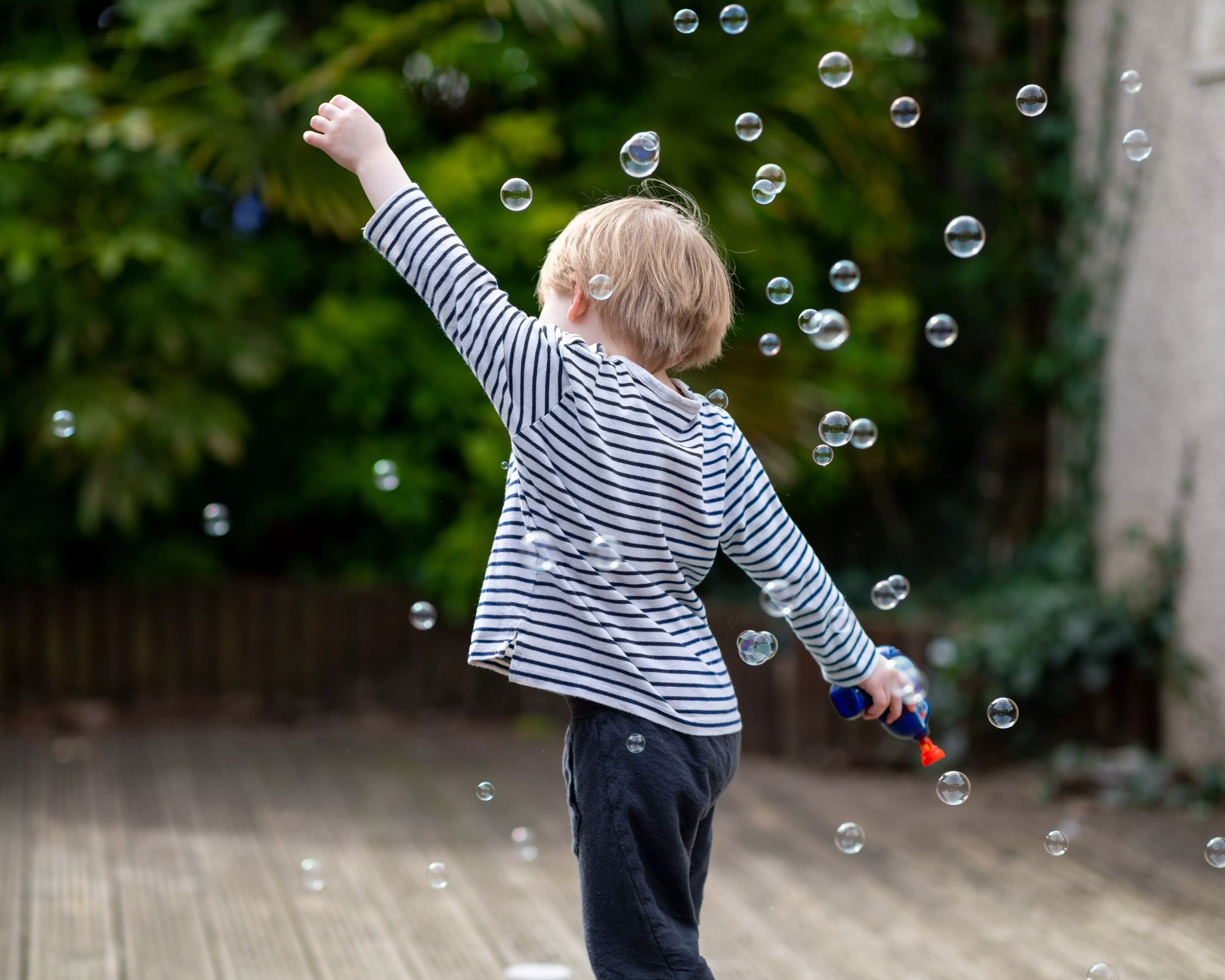 Un niño pequeño jugando con pompas de jabón / Unsplash