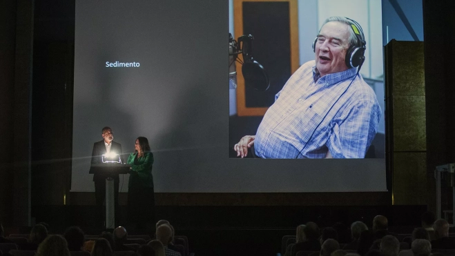 Luis Roca y Marta de Santa Ana, director y productora de 'Benito Pérez Buñuel', intervienen acompañados por una imagen de Jerónimo Saavedra. / AH