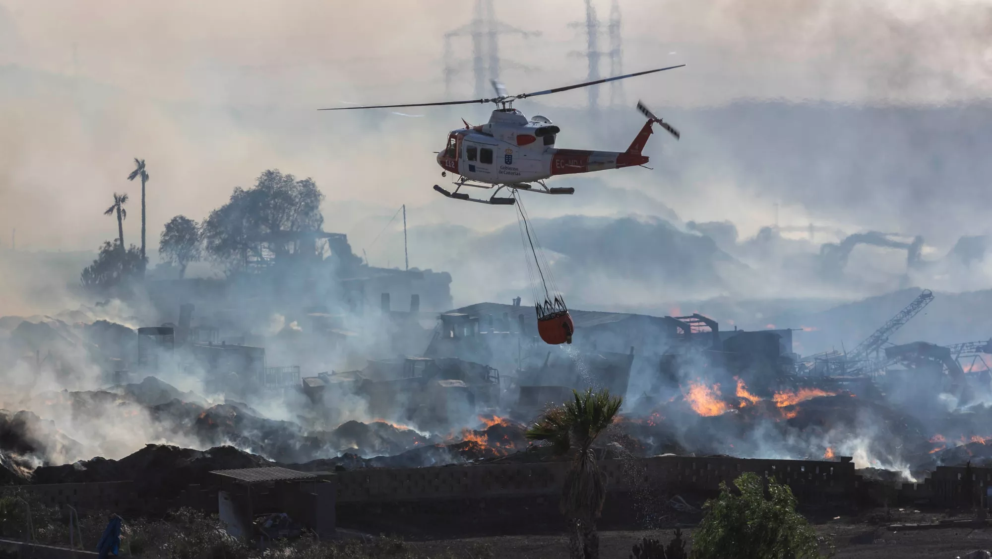Un helicóptero del GES actúa en el incendio de la planta de compostaje en el sur de Tenerife. / MIGUEL BARRETO-EFE