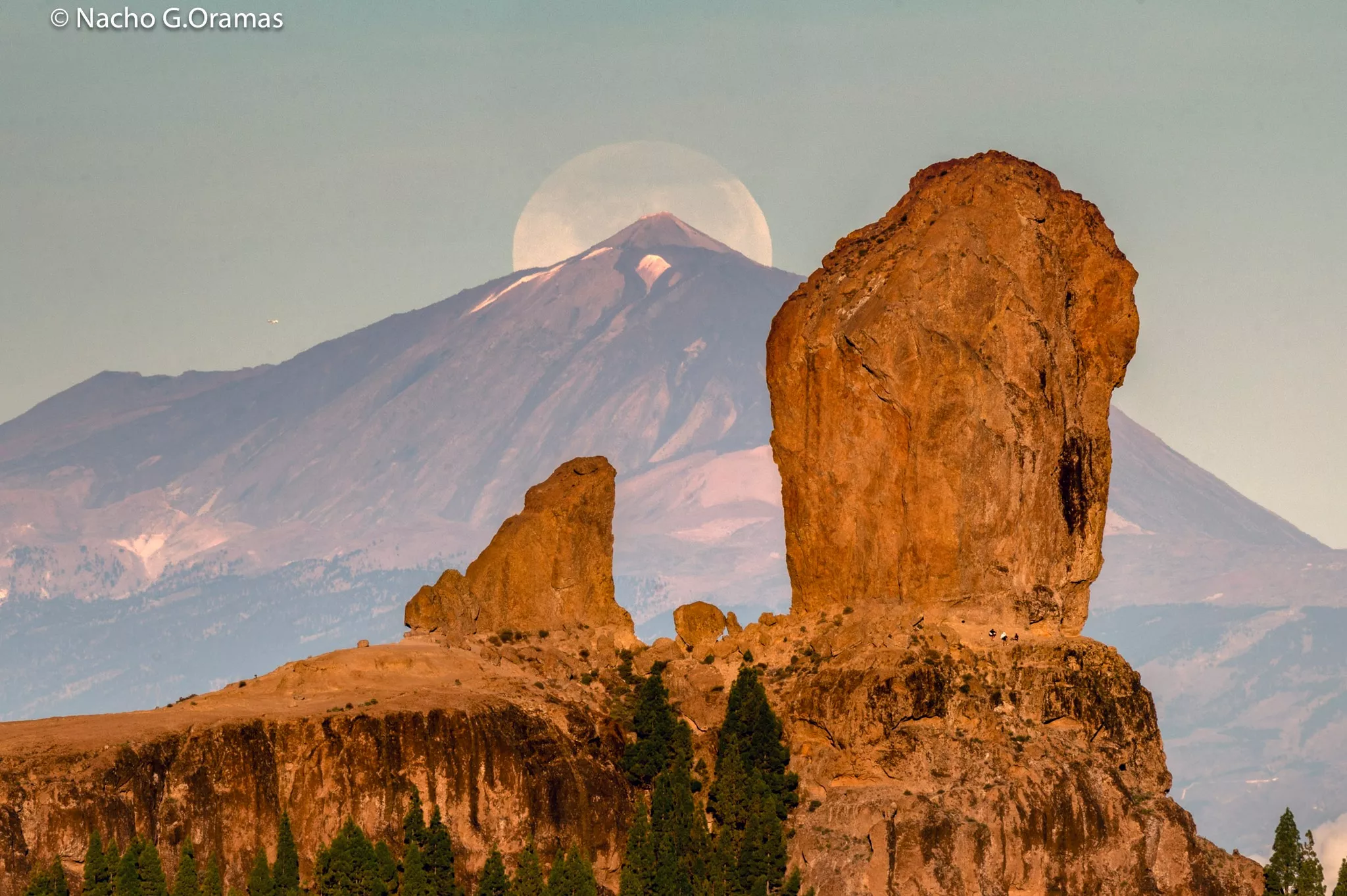 El Roque Nublo (Gran Canaria) y El Teide (Tenerife) de fondo, con la luna escondiéndose tras él./ NACHO GONZÁLEZ ORAMAS