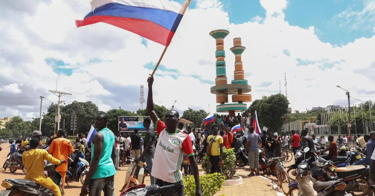 África rompe sus cadenas con Francia: el Franco CFA cae y Canarias aguarda el impacto. En la imagen, un hombre ondea una bandera de Rusia en Burkina Faso, en el corazón del Sahel. / ASSANE OUEDRAOGO-EFE