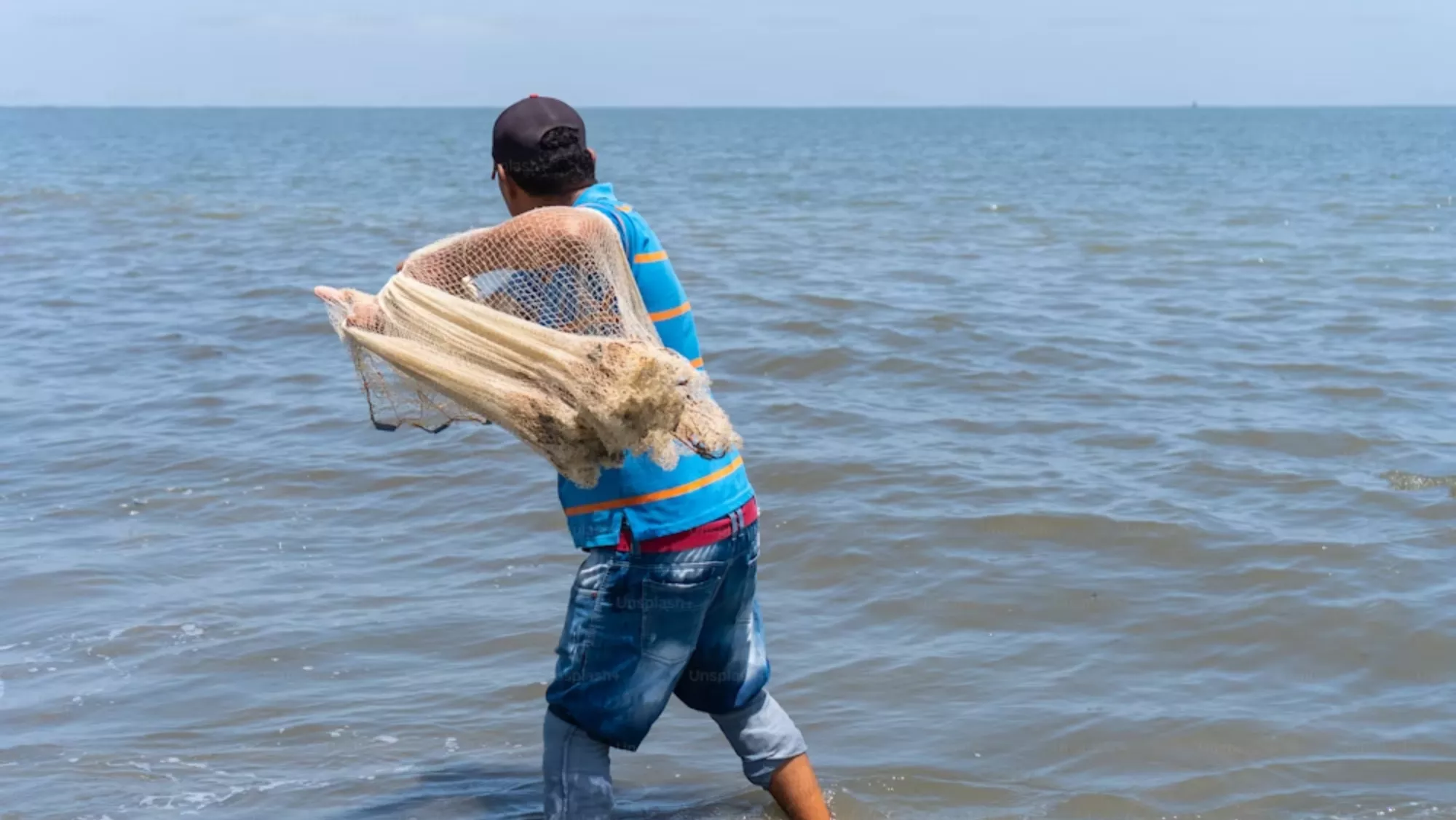 Imagen de un pescador con una red / UNSPLASH