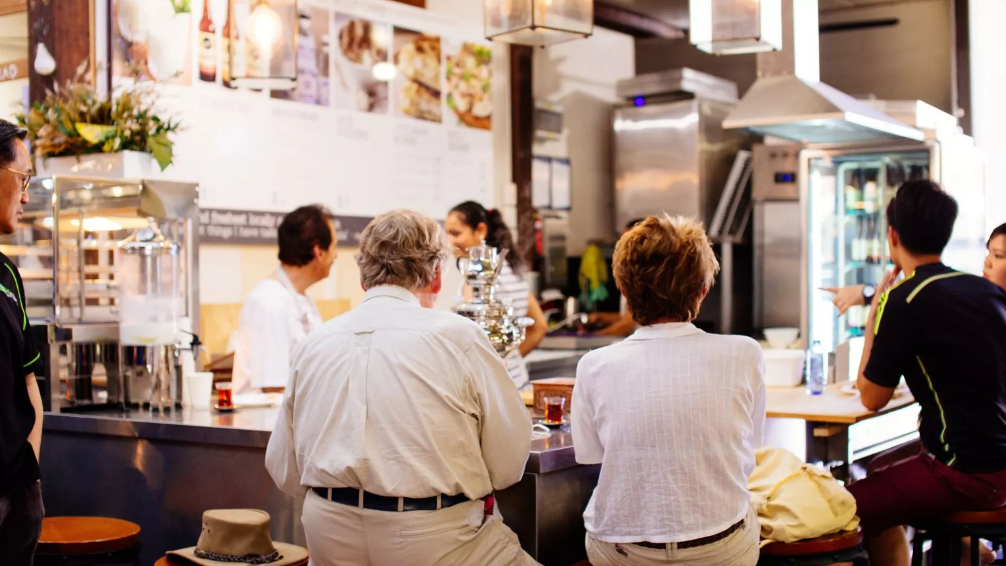 Imagen de varias personas sentadas en un bar / PEXELS
