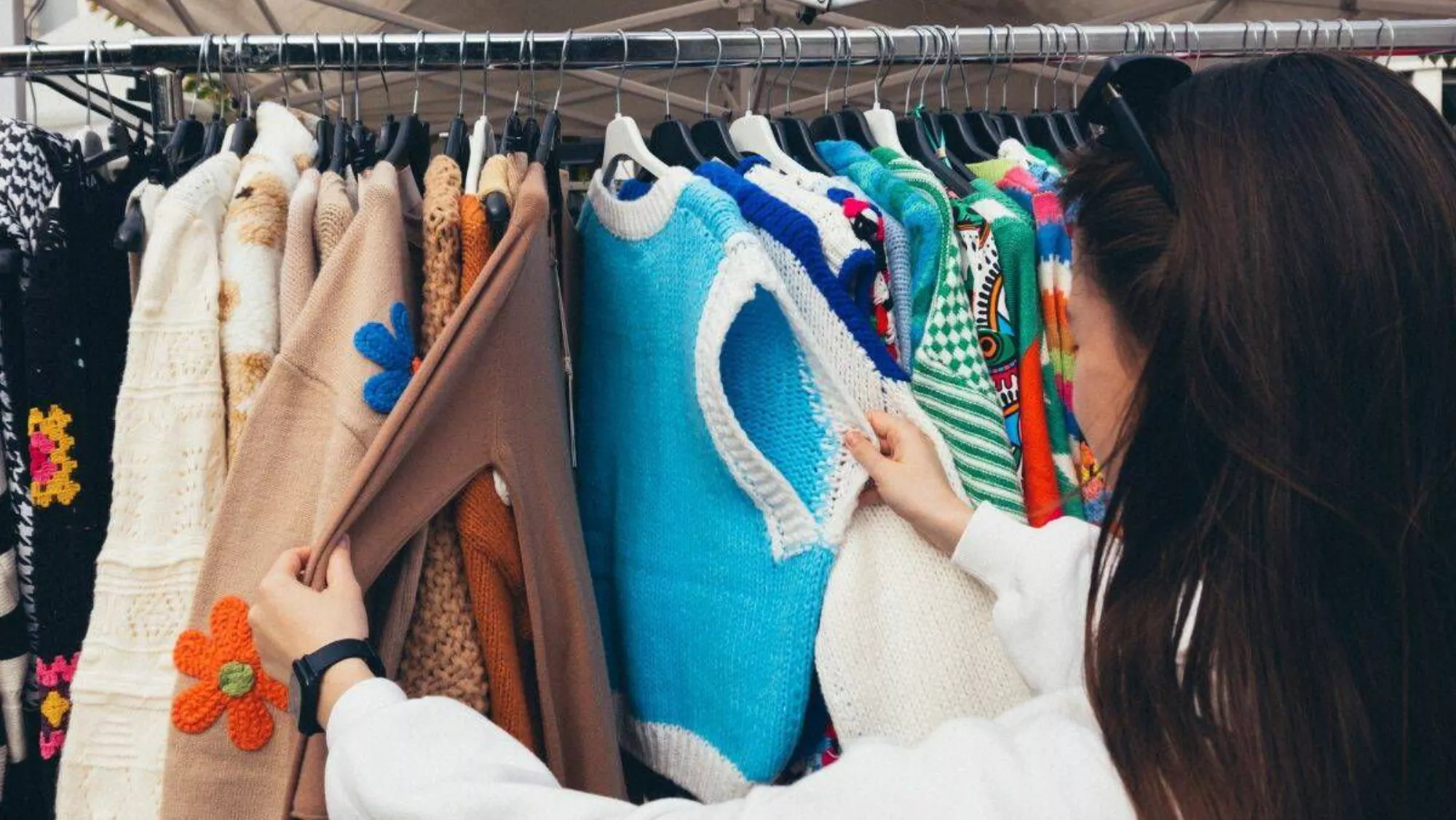 Imagen de una mujer mirando ropa en un mercadillo / PEXELS