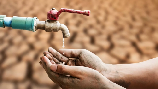 Una persona intentando conseguir agua en un periodo de sequía por el cambio climático / AH