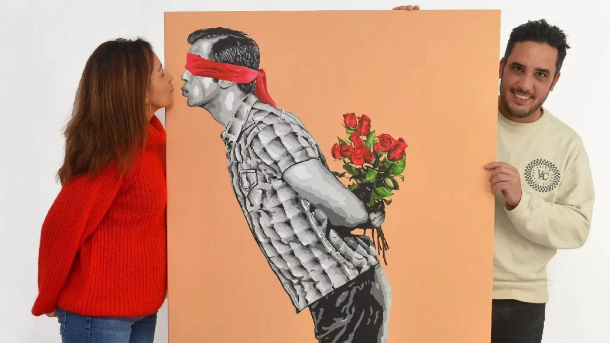 Pintura original de 'El beso', del artista tinerfeño Alberto León, quien aparece a su lado / ALBERTO LEÓN