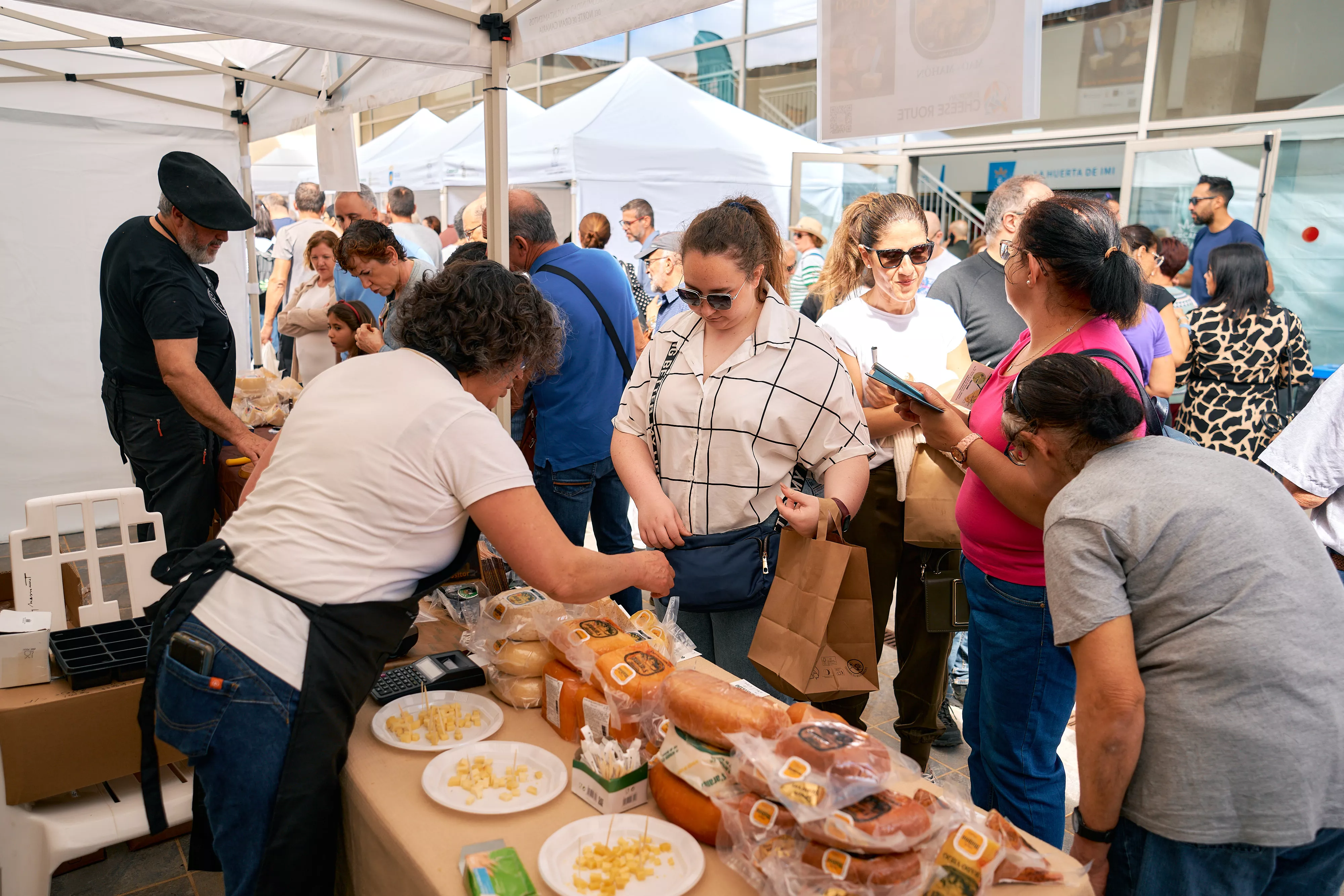 Un grupo de visitantes prueba y adquiere queso en uno de los puestos de la Feria Europea celebrada en Guía. / AH
