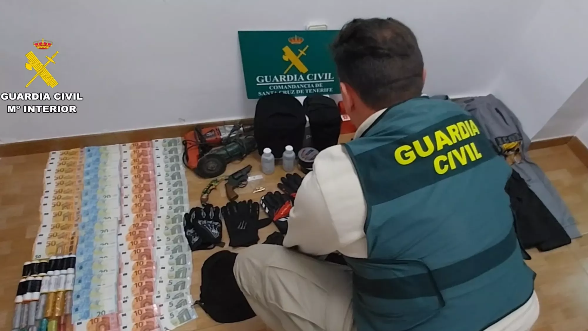 Un agente de la Guardia Civil ordena los objetos incautados a tres ladrones que atracaron una gasolinera en El Médano./ CEDIDA