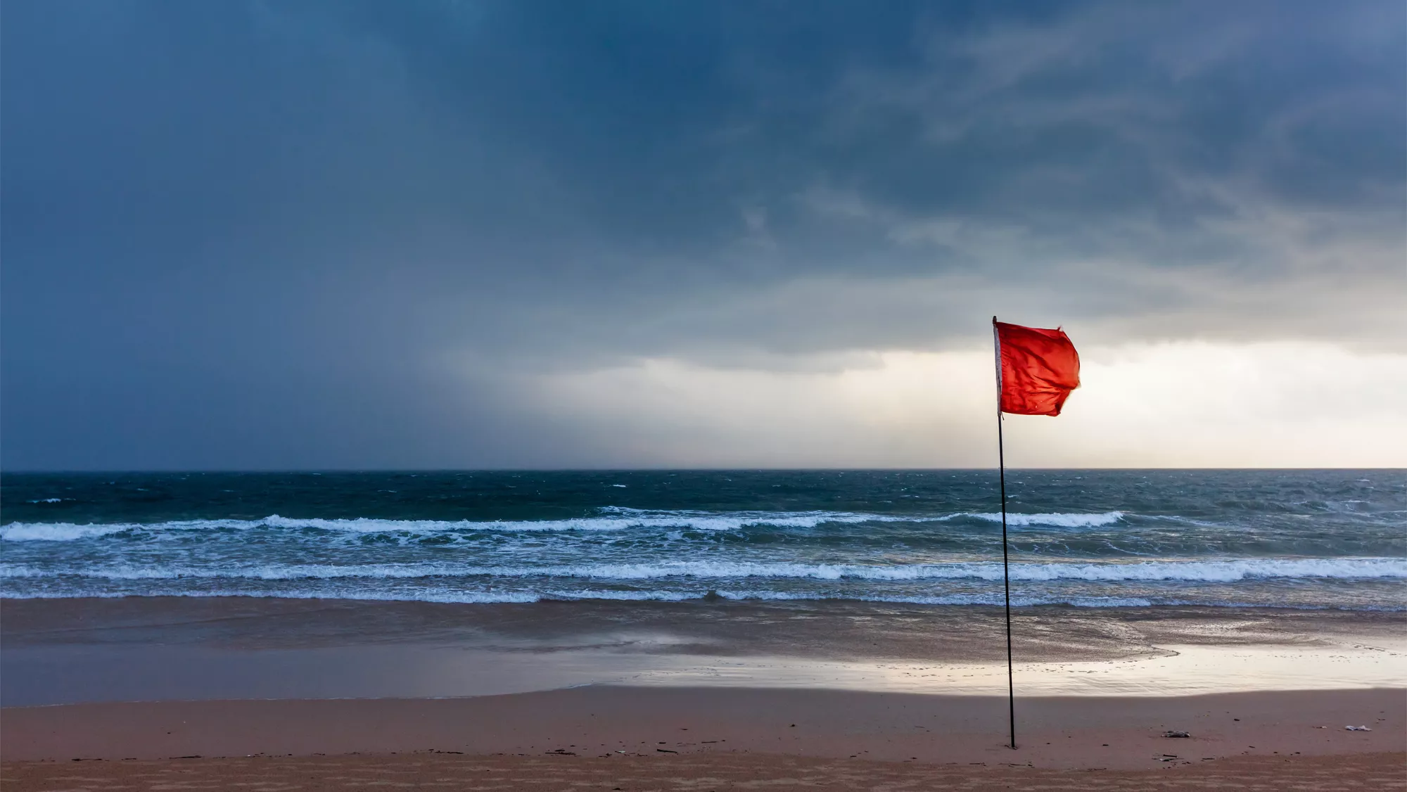 Bandera roja en una playa / AH