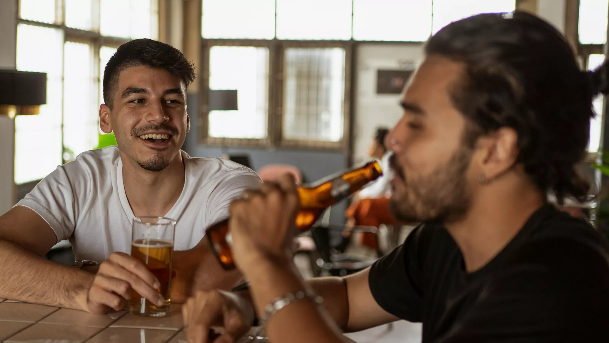 Imagen de dos personas hablando en un bar / PEXELS