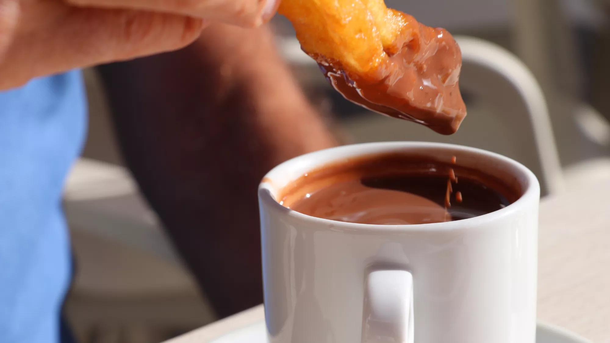 Imagen de una persona comiendo churros con chocolate / AH