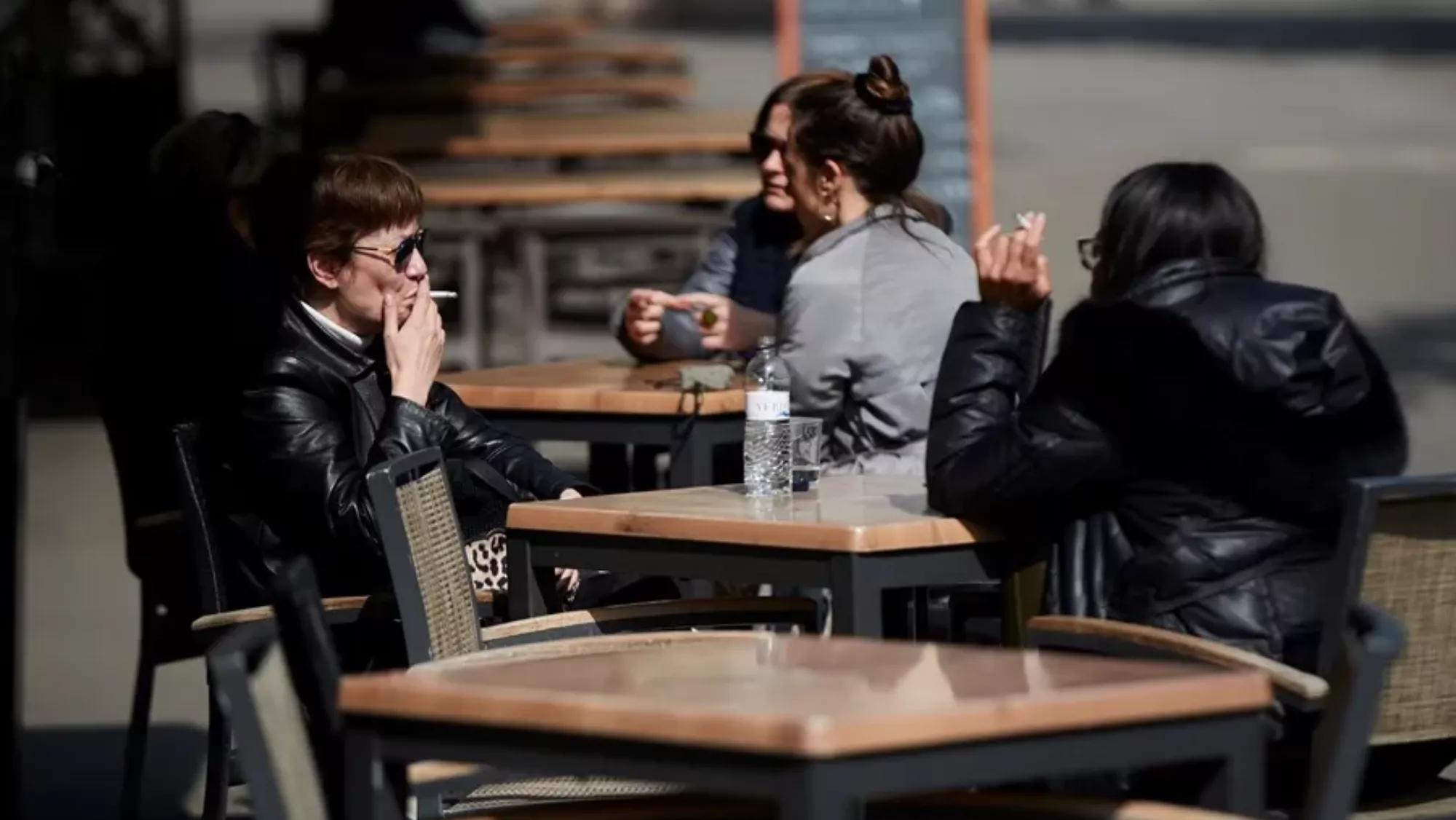 Personas fumando en una terraza de un bar. / EFE